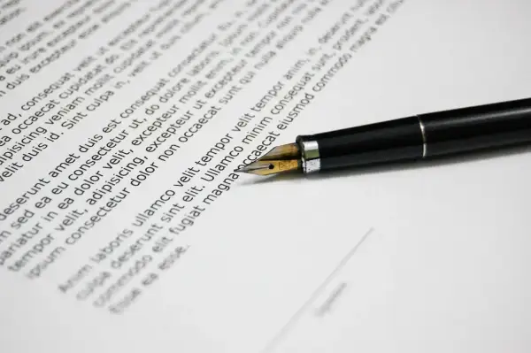 Czarny pióro na dokumencie z tekstem, gotowe do podpisania umowy przedwstępnej.