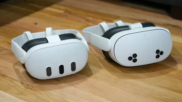 Dwa białe gogle VR Meta Quest 3 na drewnianym blacie.