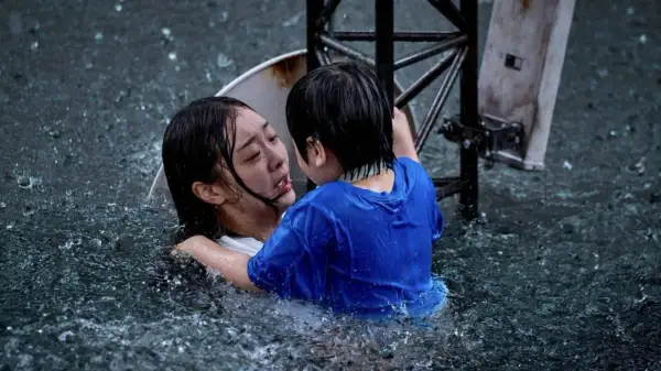 Dramatyczna scena z najlepszych filmów koreańskich: dziecko obejmuje tonącą kobietę w ulewnym deszczu.