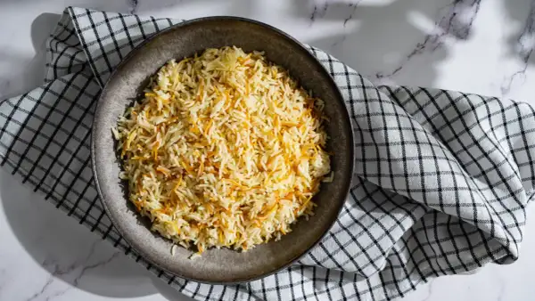 Un plat de riz libanais, parsemé de vermicelles dorés, servi sur une serviette à carreaux.