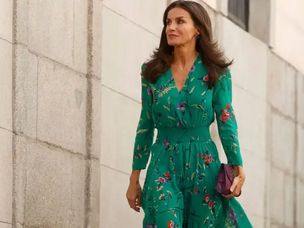 Letizia Ortiz luce un elegante vestido verde estampado con flores, portando un bolso morado.