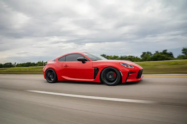 Deportivo rojo en carretera, con un escape que promete pops and bangs. Precio a consultar.