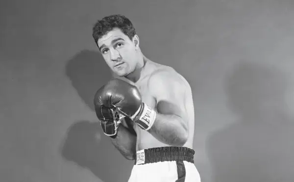 Boxer Rocky Marciano poses with his powerful Rocky Marciano hands in boxing gloves, ready for action.
