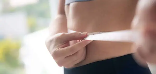 Misura della vita con metro, per capire quante calorie bisogna bruciare al giorno per raggiungere i propri obiettivi di benessere.