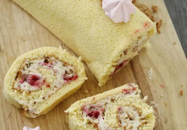 Puszysta rolada biszkoptowa z mascarpone i malinami, udekorowana różową bezą. Idealna na deser.