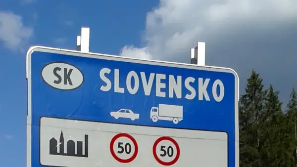 Granica Słowacji. Znak informuje o ograniczeniu prędkości do 50 km/h. Warto sprawdzić, ile kosztuje winieta na Słowacji przed podróżą.