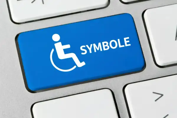 Niebieski klawisz z symbolem osoby na wózku inwalidzkim i napisem "SYMBOLE". Co oznacza symbol n 12f?