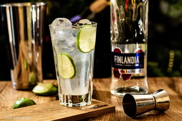 Orzeźwiający drink z lodem i limonką, obok butelka Finlandia Raspberry. Idealny na letnie wieczory.