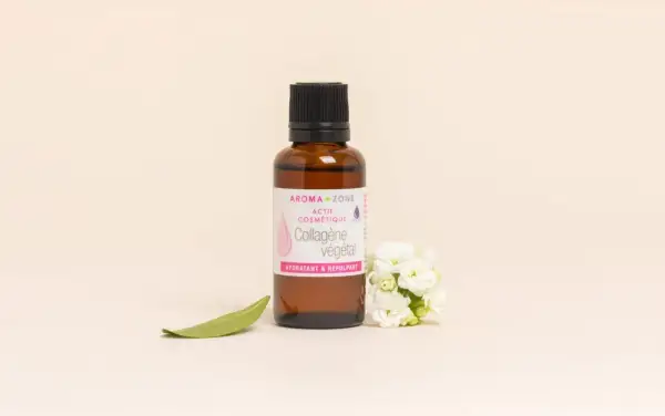 Flacon de collagène végétal Aroma-Zone, aux bienfaits hydratants et repulpants, entouré de fleurs blanches et d'une feuille verte.