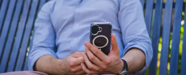 Mężczyzna trzyma telefon, który może wysyłać sygnały haptyczne.