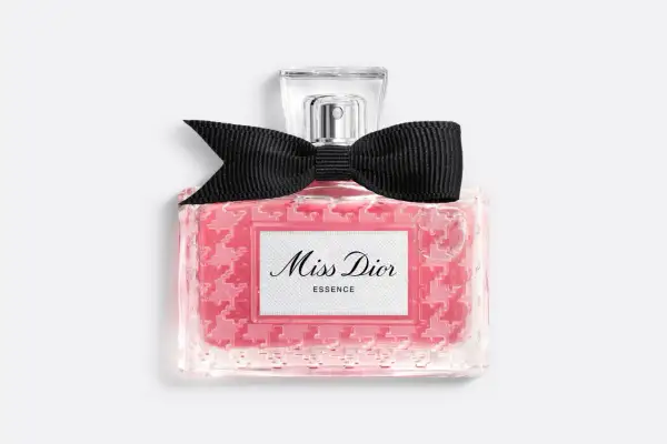 Różowy flakonik Miss Dior Essence z czarną kokardką, pachnący jak soczysta wiśnia.