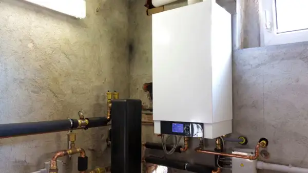 Installazione di una moderna caldaia a condensazione con tubature in rame e isolamento termico.