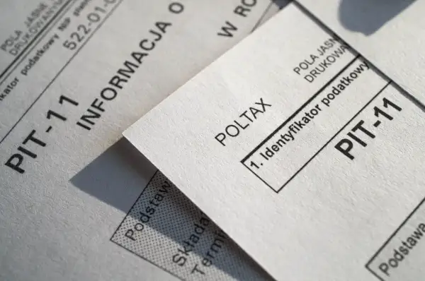 Dokumenty PIT-11 i Poltax, kluczowe dla rezydenta podatkowego, leżą obok siebie.