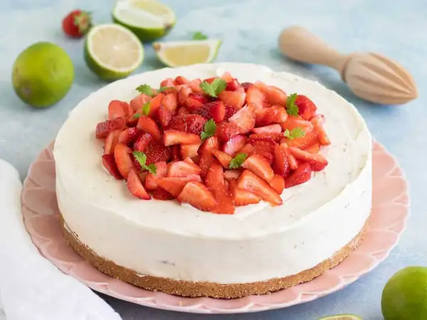 En krämig vit choklad cheesecake toppad med färska jordgubbar och mynta. En perfekt sommardessert!