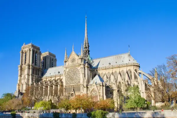 Majestatyczna katedra Notre Dame w Paryżu, idealna na **itaka wycieczka do Paryża samolotem**. Wspaniała architektura i jesienne drzewa.