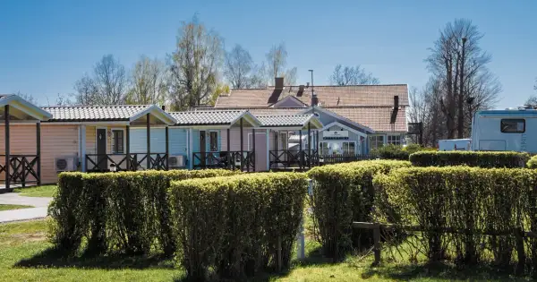 Färgglada stugor och reception vid Villa Björkhagen, Jönköping. En husbil syns till höger.