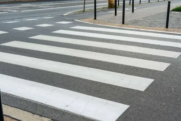 Lignes blanches sur l'asphalte, un passage piéton invite à traverser la rue en toute sécurité.