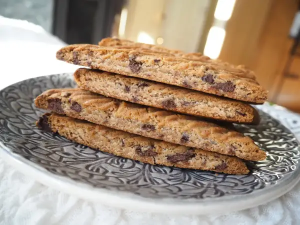 En stapel hembakade kolasnittar med choklad, redo att avnjutas.