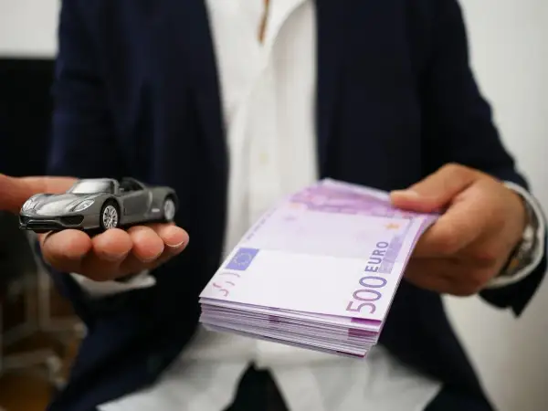Model samochodu i stos banknotów 500 euro symbolizują cesję leasingu.