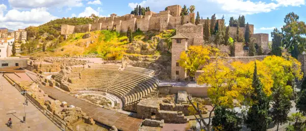 Vestiges d'un théâtre romain et de l'Alcazaba, un site historique à visiter à Malaga, sous un ciel bleu éclatant.