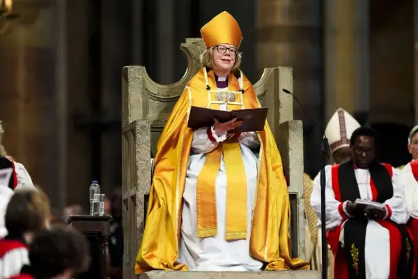 Arcybiskup Canterbury w złotej szacie i mitrze, siedzi na tronie, trzymając księgę.