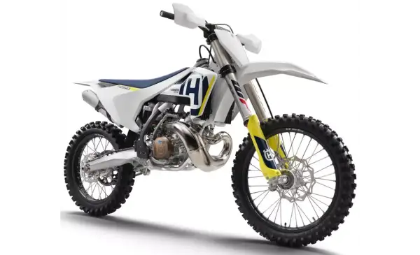 Nowy motocykl cross Husqvarna 250 gotowy na wyzwania toru. Biało-niebiesko-żółte malowanie, potężny silnik i terenowe opony.
