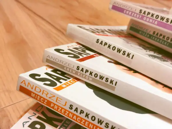 Stos książek Andrzeja Sapkowskiego, w tym "Miecz Przeznaczenia" i "Krew Elfów".