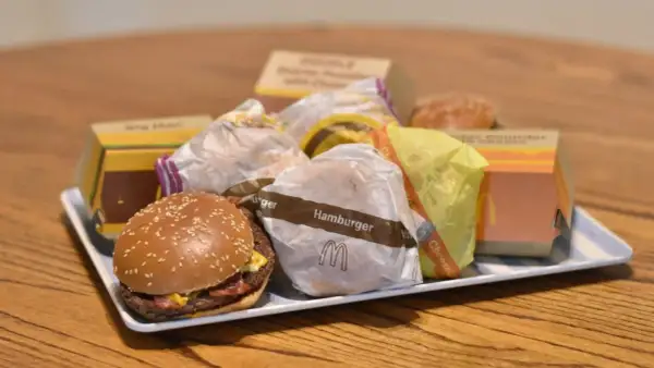 Taca pełna hamburgerów z McDonald's. Widać opakowania Big Mac, McRoyal i inne.