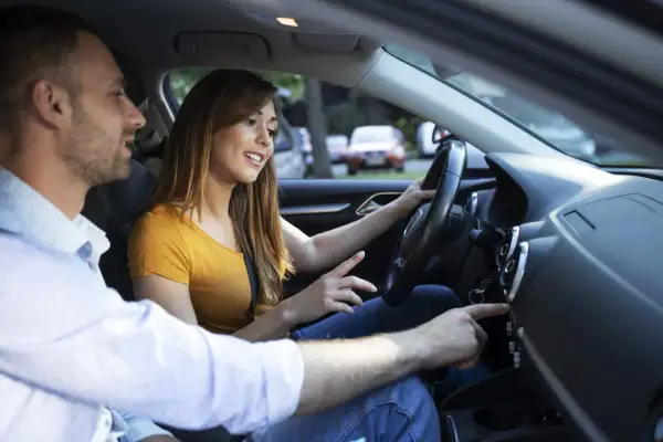 Un jeune couple discute en voiture. Elle conduit, il lui montre quelque chose sur le tableau de bord. La conduite accompagnée 3000 km en combien de temps ?