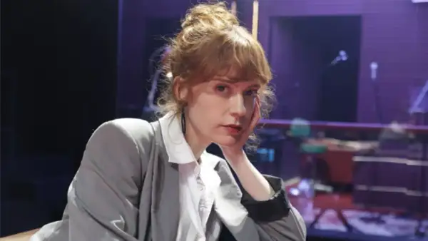 Itsaso Arana, con su cabello recogido y un gesto pensativo, posa con un traje gris sobre una camisa blanca.