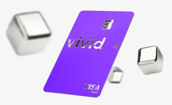 Fioletowa karta płatnicza Vivid Visa Debit, otoczona metalicznymi sześcianami, symbolizuje dostęp do żywych pieniędzy i nowoczesnych płatności.
