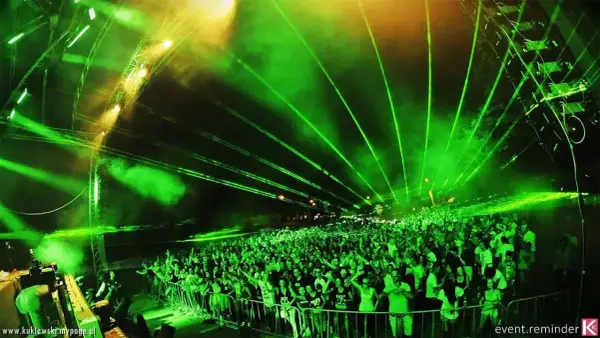 Tłum ludzi na festiwalu **Audiolake** pod zielonymi laserami i światłami.