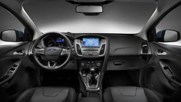 Interiör i en Ford Focus MK2 med ratt, instrumentpanel och mittkonsol. Navigationssystemet visar en karta.