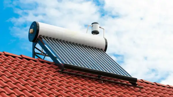 Kolektor słoneczny na dachu do grzania wody. Fotowoltaika w akcji, wykorzystująca energię słońca.