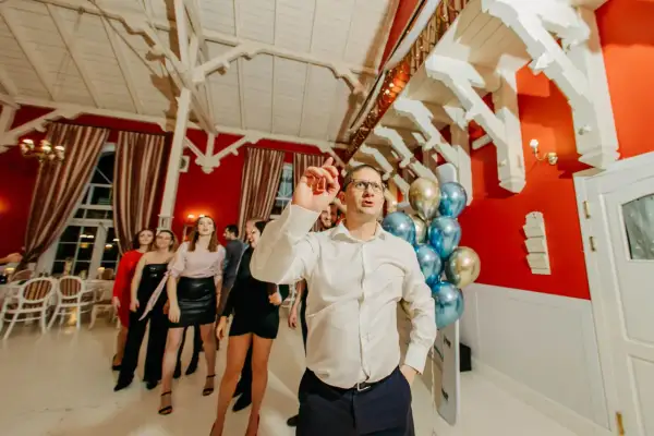 Ludzie tańczą na imprezie firmowej. W tle balony i dekoracje, świetne pomysły na jubileusz firmy.