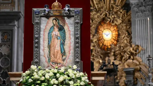 Matka Boża z Guadalupe, jej przesłanie pokoju i nadziei, w otoczeniu kwiatów i ozdobnej ramie, w kościele.