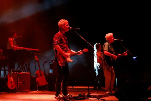 Kiko Veneno y Martirio en concierto, con luces rojas y humo. Kiko toca la guitarra eléctrica, Martirio la acústica.