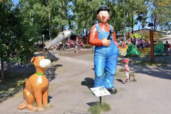 En stor staty av en mekaniker och en hund välkomnar besökare till lekparker i Stockholm.