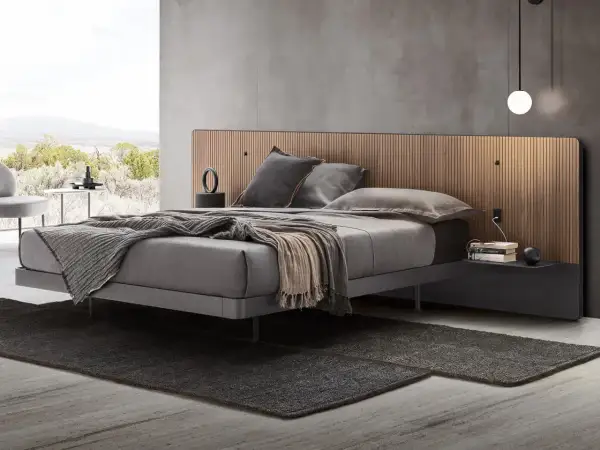 Elegante camera da letto con letto grigio e testiera in legno. Il colore grigio abbinamento crea un'atmosfera rilassante.