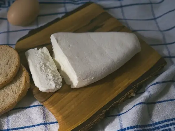 Świeży twaróg, kromki chleba i jajko na desce. Zastanawiasz się, czy twaróg można mrozić? Tak, można!