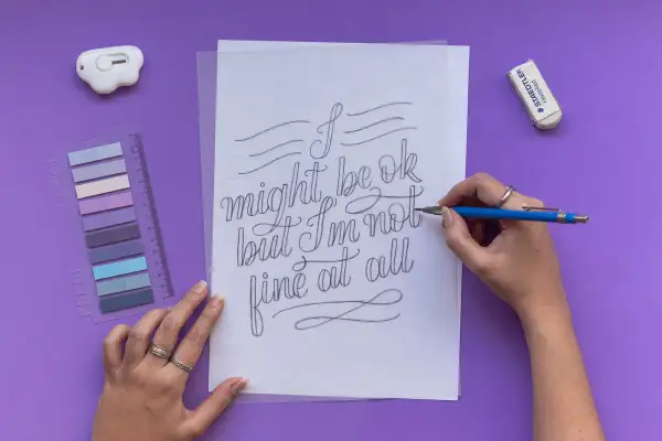 A hand draws "I might be ok but I'm not fine at all" in elegant cursive script.