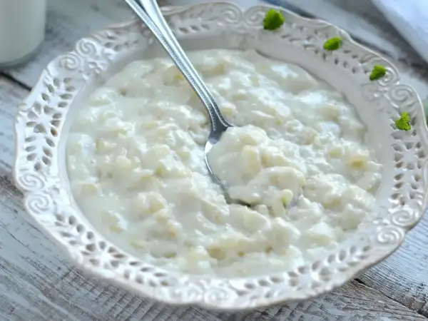 Pyszna, kremowa zupa mleczna z ryżem, podana w ozdobnej miseczce. Idealna na śniadanie lub deser.
