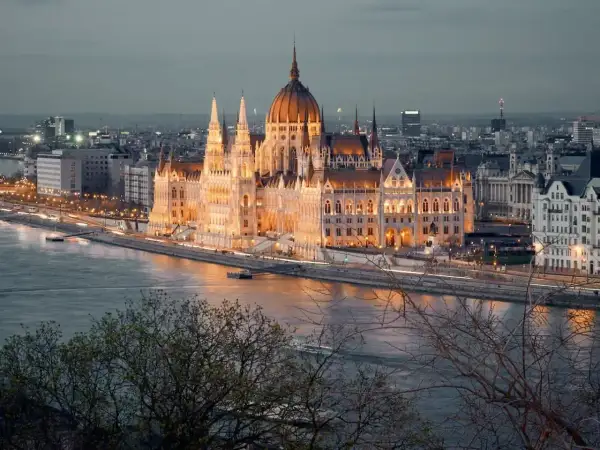 Wspaniały Parlament w Budapeszcie, oświetlony nocą, to obowiązkowy punkt, co zobaczyć w Budapeszcie. Rzeka Dunaj i miejska panorama tworzą magiczny widok.