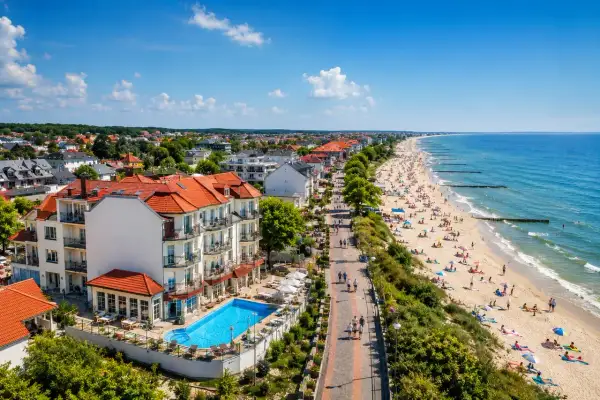 Fajny hotel nad morzem z basenem i widokiem na plażę pełną turystów. Idealne miejsce na wakacje.