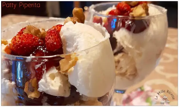 Coppa con gelato allo yogurt greco, fragole fresche, salsa rossa e noci croccanti. Un dessert fresco e goloso.