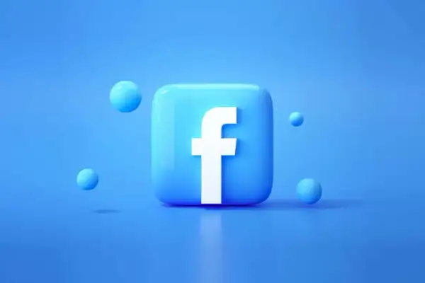 Błękitny, błyszczący kwadrat z białym "f" – tak wygląda faktura z Facebooka. Wokół unoszą się małe, niebieskie kuleczki.