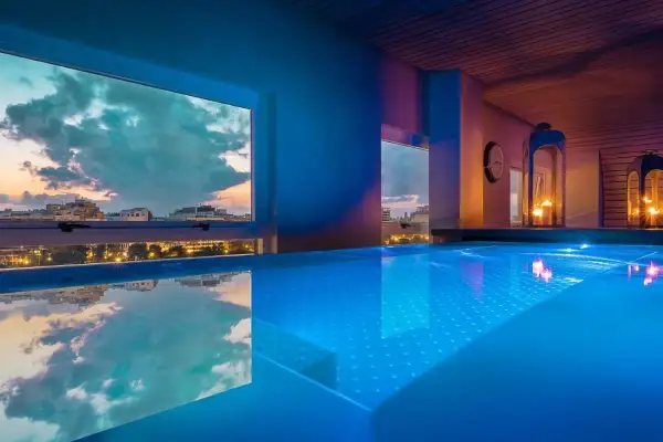 Piscina iluminada con vistas al atardecer de la ciudad. Un lugar perfecto para un día de spa en Valencia.