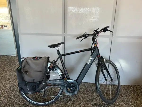 Zwarte Sparta Ion E Speed 2016 e-bike met dubbele fietstassen, klaar voor een rit.