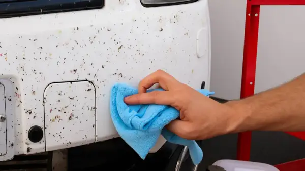 Limpia los restos de insectos del coche con un paño azul. Aprende cómo quitar los mosquitos del coche fácilmente.