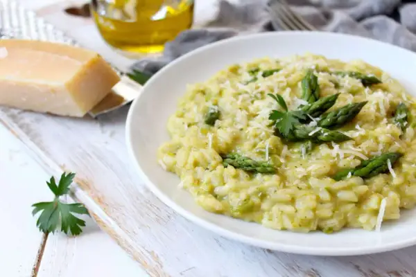 Un crémeux risotto asperges, parsemé de parmesan râpé et garni de jeunes pousses vertes. Un délice printanier.